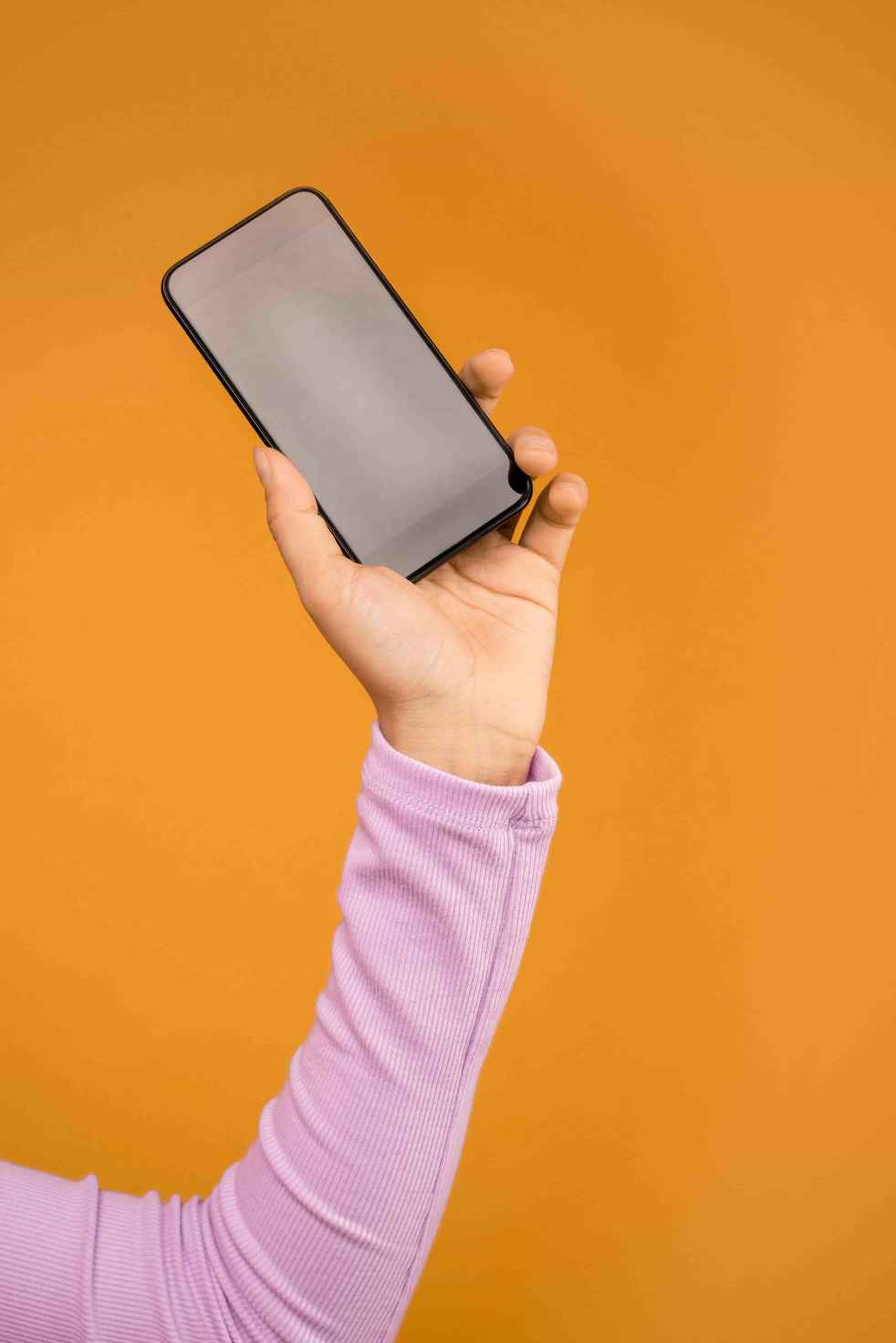 Segurando um celular que representa o desenvolvimento mobile na Magma Digital